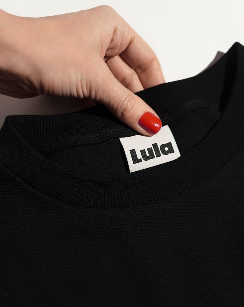 Close-up of the black nursing t-shirt collar and LULA brand label.