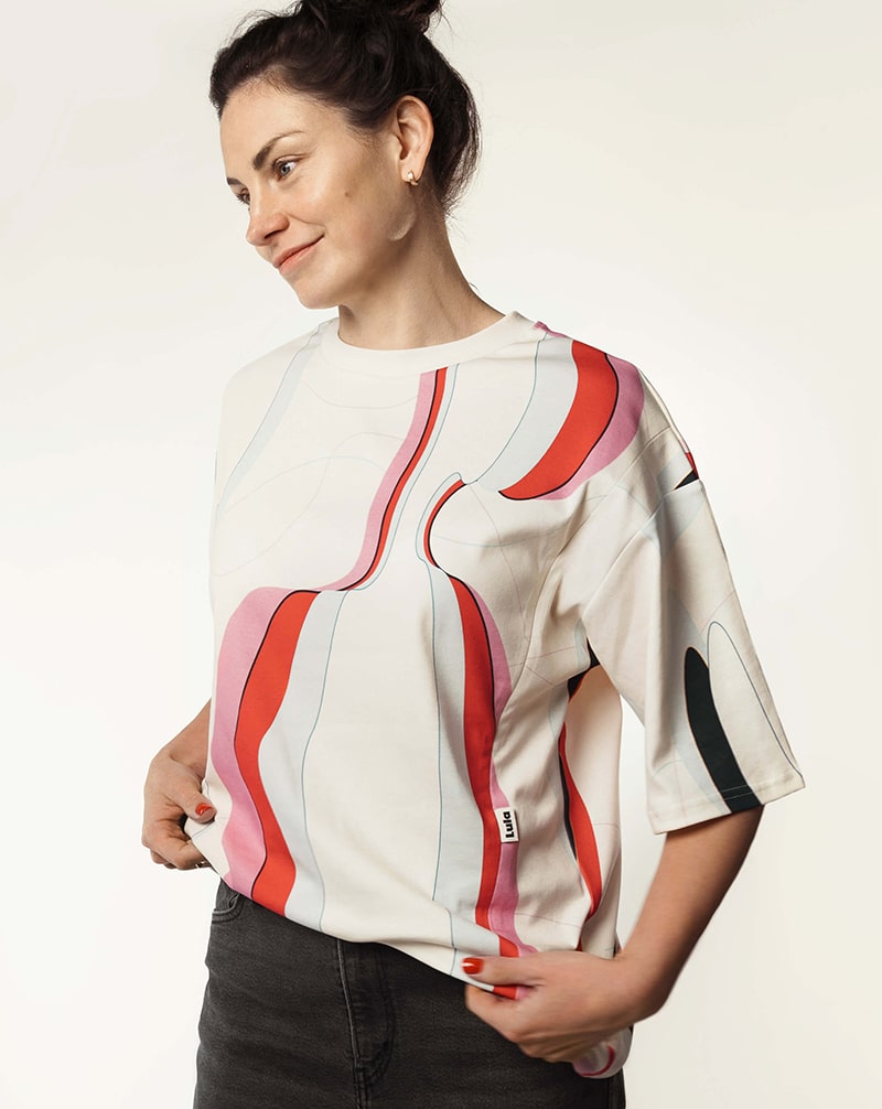Woman wearing a loose colorful nursing t-shirt, ideal for sustainable breastfeeding fashion.