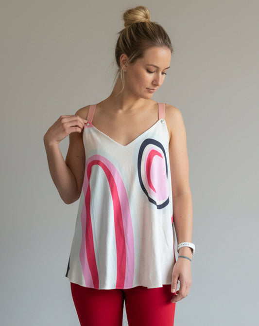 Woman wearing a sleeveless top with abstract patterns against a plain background