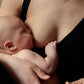 Mother holding her baby in a black nursing top, showcasing a sustainable Nursing outfit.