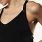 Close-up of a woman in a loose black nursing top featuring wide back straps and metallic poppers.