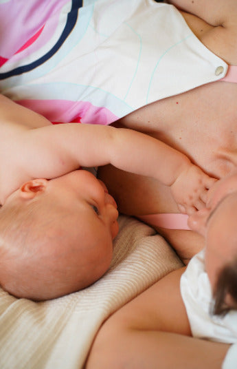 close up of mother breastfeeding her child while wearing a colorful nursing top with a built-in bra. Stylish and comfortable breastfeeding clothes for nursing moms.