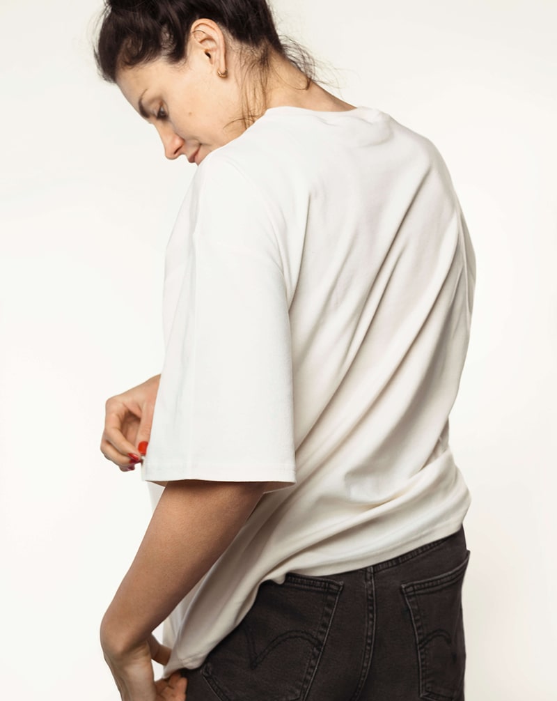 Back view of a white nursing t-shirt, highlighting its oversizded fit and smart design.