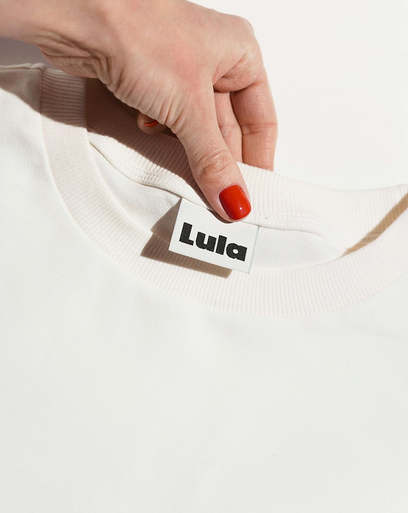 Close-up of the white nursing t-shirt collar and the LULA brand label.