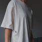 Video of a model demonstrating a white oversized nursing t-shirt with easy breastfeeding access.