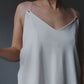 Video of a model demonstrating a white nursing top with snap-button fastening for easy breastfeeding access.